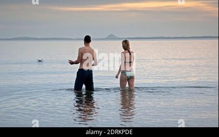 Portobello, Edimburgo, Scozia, Regno Unito. 21 dicembre 2020. Segnando il Solstizio d'inverno Anna e Andrew si tuffano al mattino presto all'alba nel Firth of Forth. Il giorno più breve dell'anno, segnando l'inizio dell'inverno. Credit: Arch White/Alamy Live News. Foto Stock