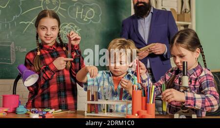 Preparazione agli esami. Bambini che fanno esperimenti scientifici. Istruzione. Scienza e istruzione. Laboratorio di chimica. Insegnante felice di bambini. Ritorno a scuola. Fare esperimenti con liquidi in laboratorio di chimica. Foto Stock