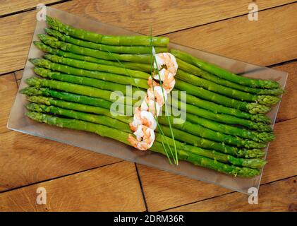 Verde e arancione composizione. Gustosi gli asparagi e gamberetti Foto Stock