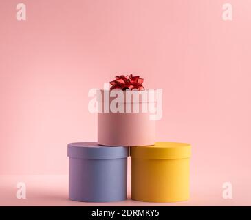 Piramide di scatole regalo rotonde su sfondo rosa Foto Stock