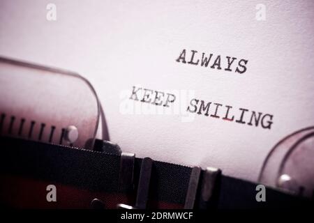 Mantenere sempre sorridente frase scritta con una macchina da scrivere. Foto Stock