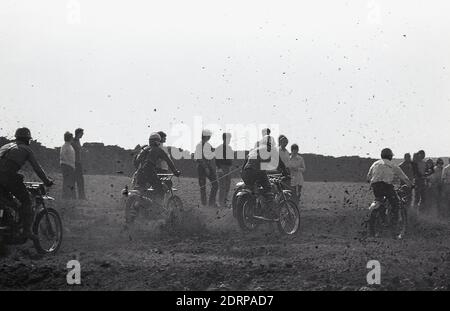 Anni '1970, storico, lo sporco vola via mentre i concorrenti prendono parte a una corsa motociclistica, Inghilterra, Regno Unito. Foto Stock