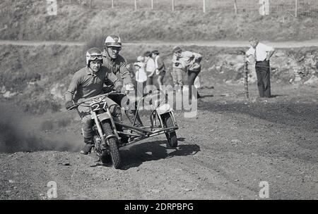 Anni '1970, storico, Motorcross....fuori sul circuito sterrato, due piloti maschi su una moto e sidecar che gareggiano in un evento di corsa, Inghilterra, Regno Unito. Foto Stock