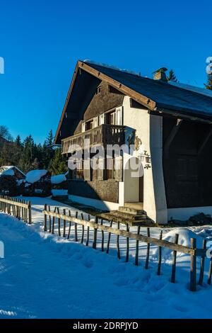 Rifugio alpino in Austria. Bella alp, casa vacanze nella prima neve. Ferienhaus im Winter auf den Vorarlberger Bergen. Haus von alleinstehendem Baum Foto Stock