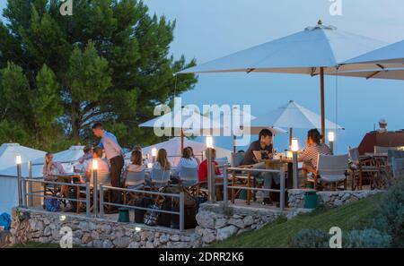 Dubrovnik, Dubrovnik-Neretva, Croazia. Terrazza esterna illuminata di un famoso ristorante in cima al Monte Srđ, il mare Adriatico oltre, crepuscolo. Foto Stock