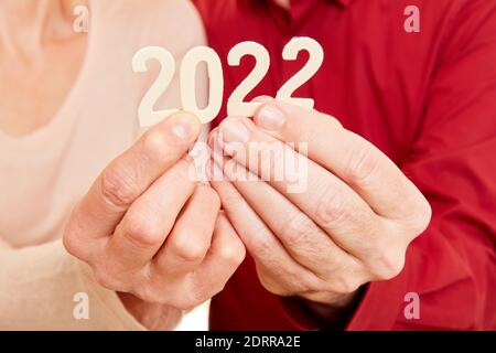 Due mani senior mostrano l'anno 2022 come un numero Foto Stock