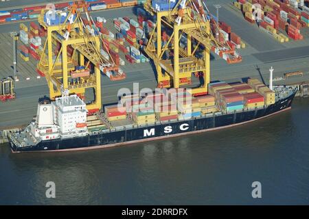 BREMERHAVEN, GERMANIA - 31 agosto 2020: Vista aerea di una nave portacontainer e gru di carico nel porto industriale di Bremerhaven - Tiro da un aereo Foto Stock