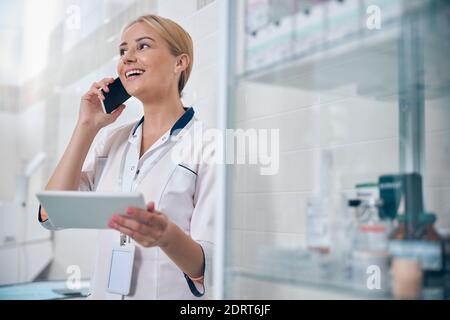 Felice dentista donna che chiama in ufficio Foto Stock