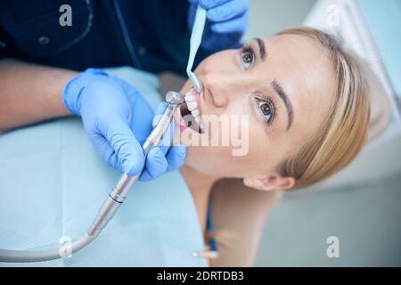 Giovane donna durante le procedure dentali in clinica Foto Stock