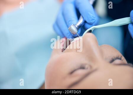 Giovane bella donna che viene trattata in clinica dentale Foto Stock