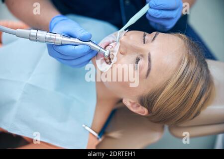 Giovane donna durante la procedura dentale in clinica Foto Stock