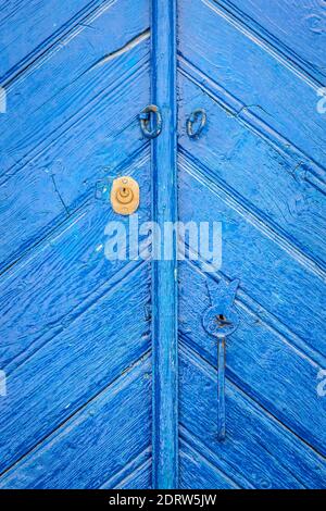 Chiusa vecchia porta di legno blu, chiaramente invecchiata e lavata a tempo. Foto Stock
