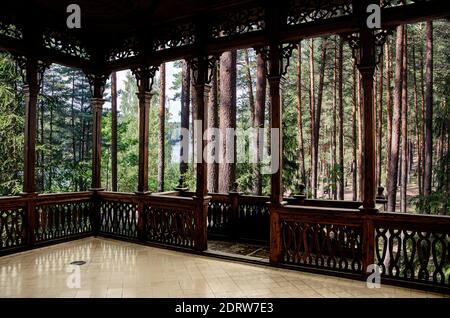 Vista della foresta di conifere con alberi di pino dalla galleria in legno aperto o gazebo. Foto Stock