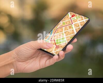 Donna irriconoscibile che utilizza l'app GPS Map Navigation sullo smartphone all'aperto Foto Stock