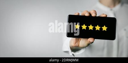 servizio eccellente e feedback dei clienti. donna che tiene il telefono con 5 stelle sullo schermo. spazio per la copia Foto Stock