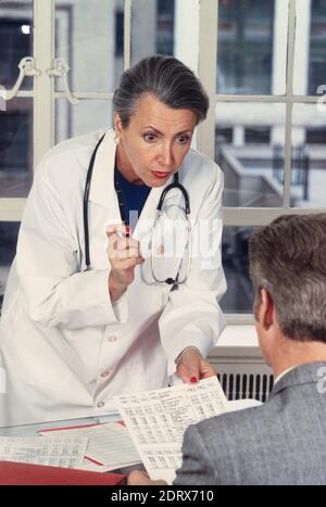 1994, Female Doctor Reviews risultati di laboratorio con un paziente di sesso maschile., USA Foto Stock