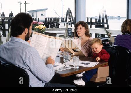 Coppia con un bambino Son gustando un pasto della famiglia ad un Dockside Restaurant sulla costa pacifica della contea di Sonoma, CA, 1995, USA Foto Stock