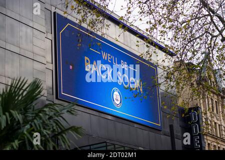 Londra, Regno Unito. 21 dicembre 2020. Il cinema Odeon Leicester Square presenta un grande cartello digitale con il testo "We'll be Back soon". Cinema, teatri e altri locali dal vivo hanno sofferto in modo particolarmente grave durante la pandemia e attualmente non c'è alcun piano per riaprirli. Le restrizioni di livello 4 sono imposte a gran parte del Regno Unito per combattere la pandemia di coronavirus in corso alla luce di un ceppo mutante scoperto di recente che si è scoperto diffondersi nel sud-est dell'Inghilterra. Credit: Stephen Chung / Alamy Live News Foto Stock