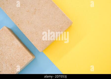 Una vista dall'alto di isolamenti termici edilizi in materiale ecologico materiali su sfondo giallo e blu Foto Stock