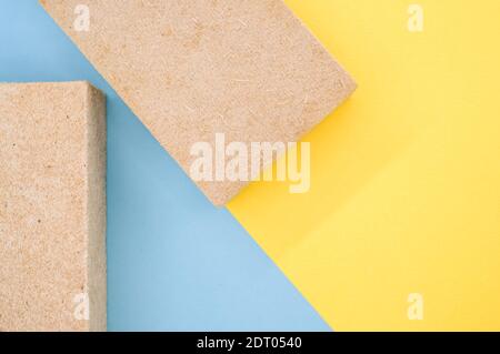 Una vista dall'alto di isolamenti termici edilizi in materiale ecologico materiali su sfondo giallo e blu Foto Stock