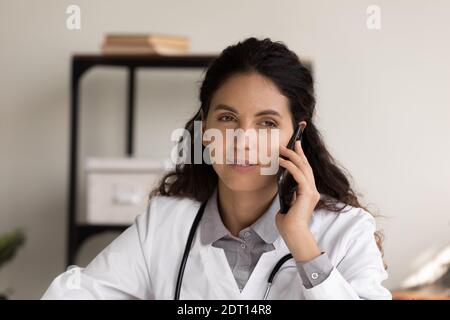 Medico femminile parlare sul cellulare in ospedale Foto Stock