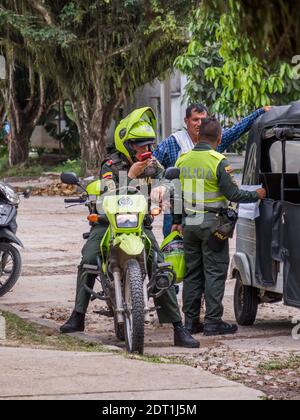 Leticia, Colombia - 21 dicembre 2019: I poliziotti controllano un'automobile sulla strada di una città tropicale nell'Amazzonia. Policia. America del Sud. Foto Stock