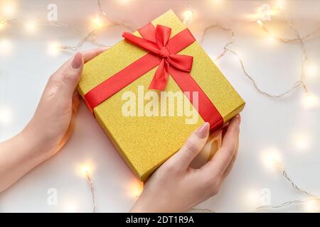 Confezione regalo nelle mani di una ragazza. Sfondo di Natale per la creatività. Messa a fuoco selettiva. Foto Stock