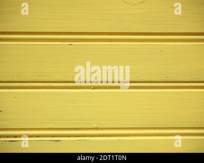 Vecchia superficie rustica e usurata in legno con tavole orizzontali verniciato giallo Foto Stock