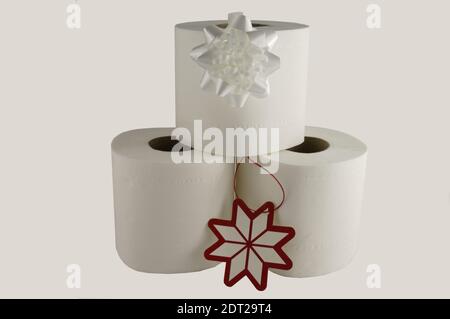 Tre rotoli di carta igienica bianca con prua bianca e etichetta regalo rossa e bianca, concetto pratico da regalo Foto Stock