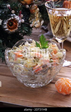 Tradizionale insalata di Natale russa Olivier con champagne e tangerini Foto Stock