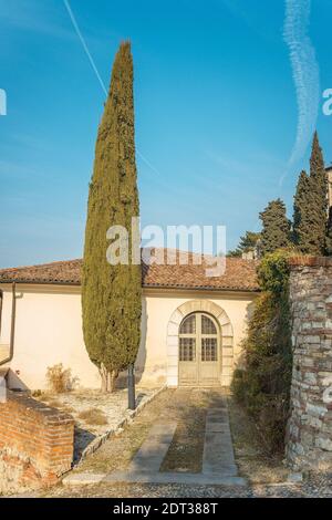 Antica casa nel castello della città di Brescia in una giornata soleggiata e limpida contro un cielo blu luminoso. Parte del castello di Brescia. Castello di Brescia, Lombardia, Foto Stock