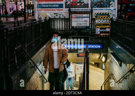 Piccadilly Circus, Londra, Regno Unito. 21 dicembre 2020. I membri del pubblico in facemasks lasciano la stazione della metropolitana di Piccadilly Circus all'ora di punta a Londra a causa delle restrizioni di livello 4. Credit: Tom Leighton/Alamy Live News Foto Stock