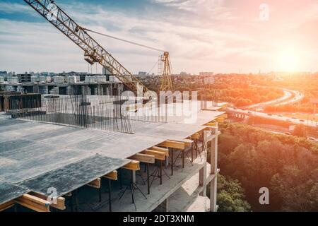 Cantiere di costruzione di nuovi edifici residenziali, gru per costruzioni industriali e altre attrezzature industriali, vista dal tetto. Foto Stock