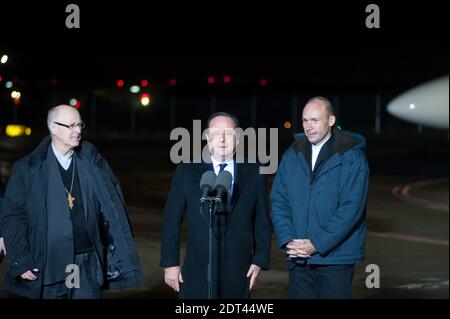 Il prete cattolico romano Georges Vandenbeusch (R), rapito dai militanti islamici in Camerun e rilasciato dopo sette settimane, è accolto dal presidente Francois Hollande il 1° gennaio 2014, in un aeroporto militare di Velizy-Villacoublay, Parigi occidentale, come guarda il vescovo di Nanterre Gerard Daucourt (L). Il sacerdote cattolico francese liberato il 31 dicembre dopo essere stato tenuto prigioniero per sette settimane dai militanti islamici in Camerun ha detto di essere 'in grande forma' e ha ringraziato coloro che hanno contribuito a ottenere la sua liberazione. Foto di Nicolas Messyasz/ABACAPRESS.COM Foto Stock