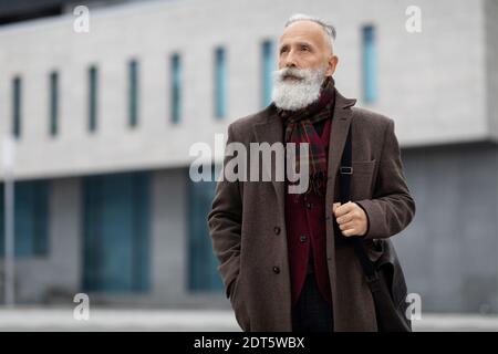 Uomo anziano premuroso che cammina a casa dal lavoro Foto Stock