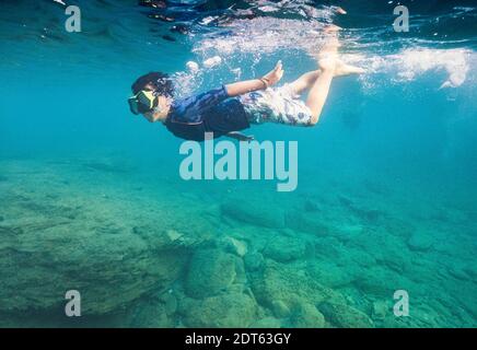 Ragazzo che indossa una maschera subacquea che nuota sott'acqua Foto Stock