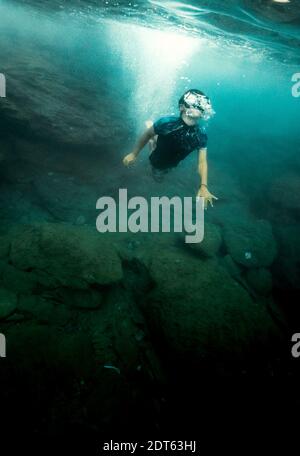 Ragazzo che indossa una maschera subacquea che nuota sott'acqua Foto Stock