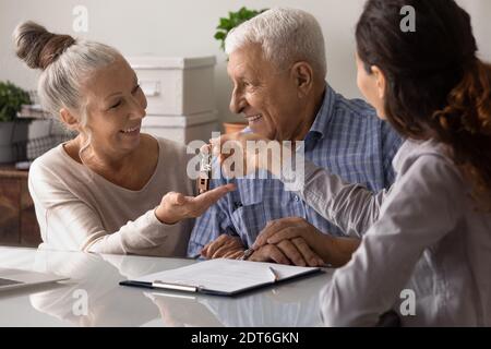 Realtor dare le chiavi ai clienti maturi eccitati Foto Stock