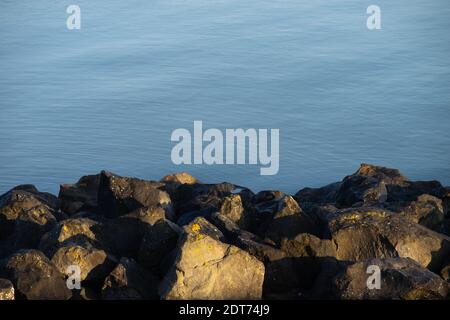 Massi sulle acque bordo al mare un sacco di pietre sulla riva Foto Stock