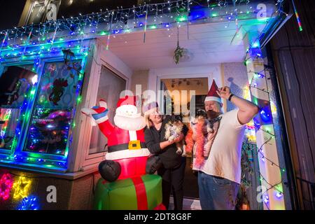 Glasgow, Scozia, Regno Unito. 21 Dic 2020. Nella foto: Famiglia di Aitcheson: Sheree; Giovanni. Gli abitanti di Balarnock hanno messo su un fantastico spettacolo di luci di Natale. I residenti di Balarnock hanno un grande senso di comunità, e amano diffondere il xmas cheer mettendo su una mostra festosa che diffonde il messaggio di Natale. In un anno in cui COVID19 ha dominato i titoli da quasi un anno, la gente gradica appena vedere le luci colorate e godere la stagione di festa. Credit: Colin Fisher/Alamy Live News Foto Stock