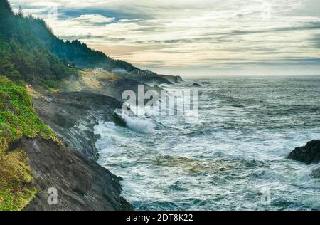 I mari pesanti si schiantano sulle rocce al largo della Otter Crest Loop, costa dell'Oregon Foto Stock