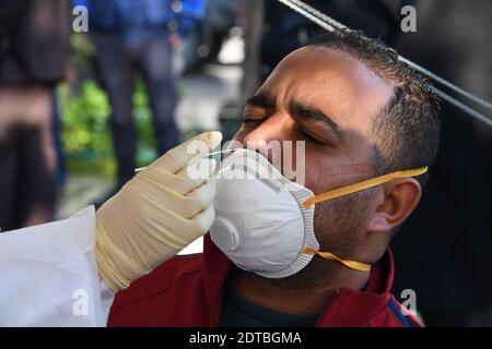 Tunisi, Tunisia. 21 Dic 2020. Un medico raccoglie un campione di tampone da un uomo per il test COVID-19 nel centro di Tunisi, Tunisia, 21 dicembre 2020. Il Governo Municipale di Tunisi ha effettuato prove libere e rapide di COVID-19 in tre zone densamente popolate della città da lunedì a mercoledì. Credit: Adel Ezzine/Xinhua/Alamy Live News Foto Stock