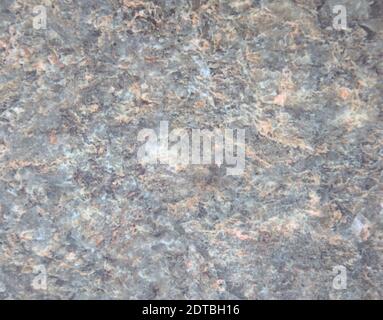 Granito blu chiaro, superficie in pietra naturale lucidata con spruzzi bianchi e marroni in primo piano. Sfondo, texture. Foto Stock