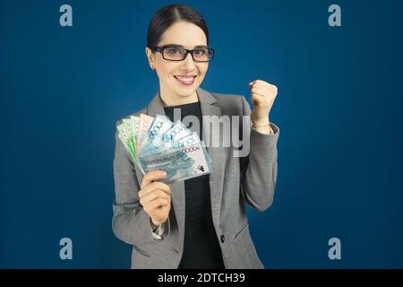 Felice giovane donna sorridente in occhiali con tenge nelle tue mani. Foto Stock