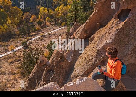 DONNA ANZIANA ESCURSIONISTA CHE SI AFFACCIA SUL MONUMENTO NAZIONALE BANDELIER, NM, USA Foto Stock