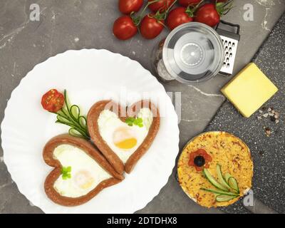 Colazione studentesca con uova e pomodori e salsiccia. La colazione è dietetica e non costosa Foto Stock