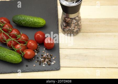 Pomodoro e cetriolo con sale marino e spezie. Insalata di pomodori ciliegini e cetrioli. Foto Stock