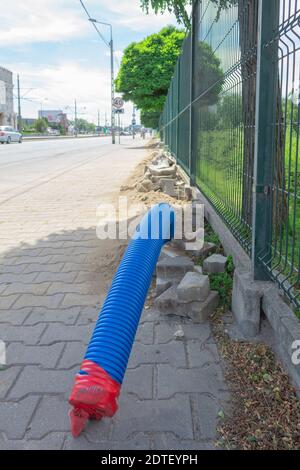 Posa di comunicazioni in tubi corrugati. Il tubo corrugato blu si trova a terra all'interno della città Foto Stock