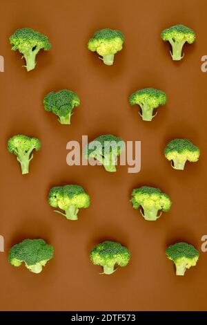 Immagine di un gruppo di broccoli grezzi posto su a. sfondo di cartone marrone e catturato dall'alto Foto Stock