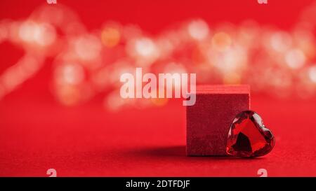 Podio vuoto per i vostri prodotti con un cuore su sfondo rosso con bokeh. Concetto di giorno di San Valentino, amore. Spazio di copia Foto Stock
